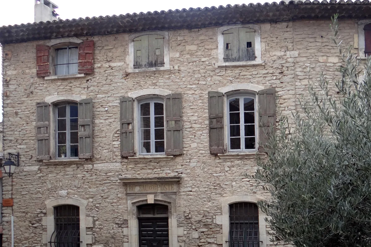Volets battants en bois sur une façade en pierre