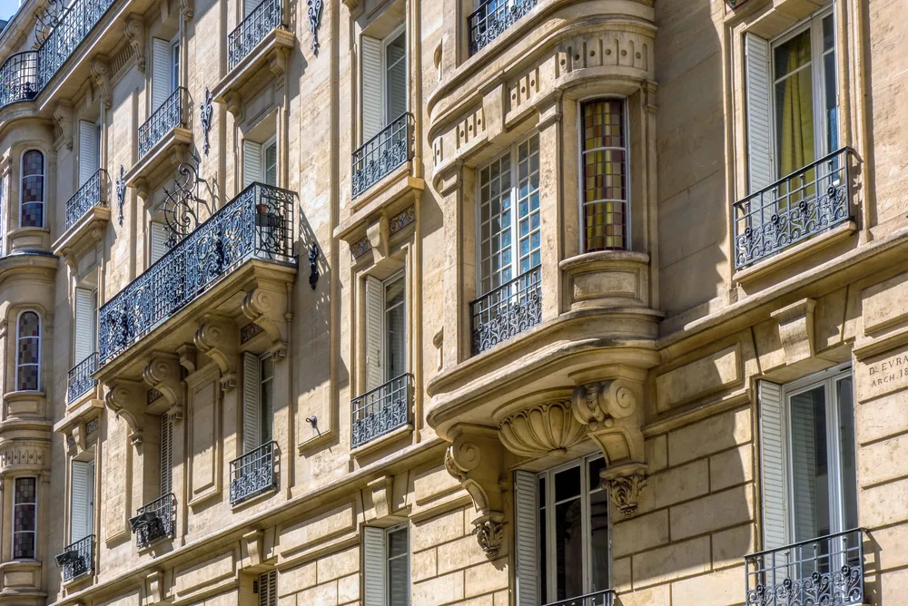 Façade haussmannienne parisienne : fenêtres, persiennes et garde-corps